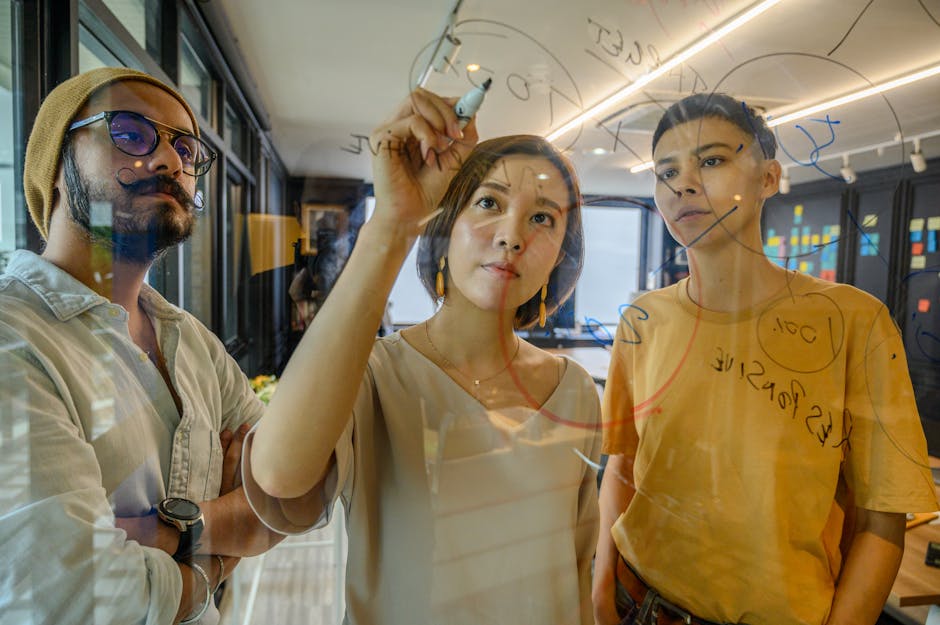 A group of diverse entrepreneurs brainstorming business ideas on a large whiteboard