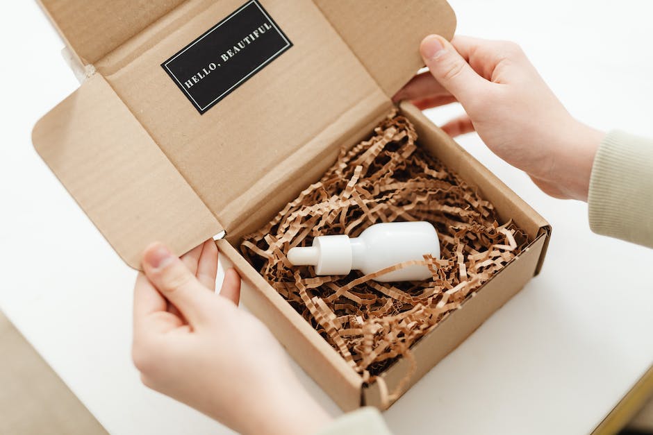 A person holding a cardboard box labeled 'drop shipping' with product images on top of it.