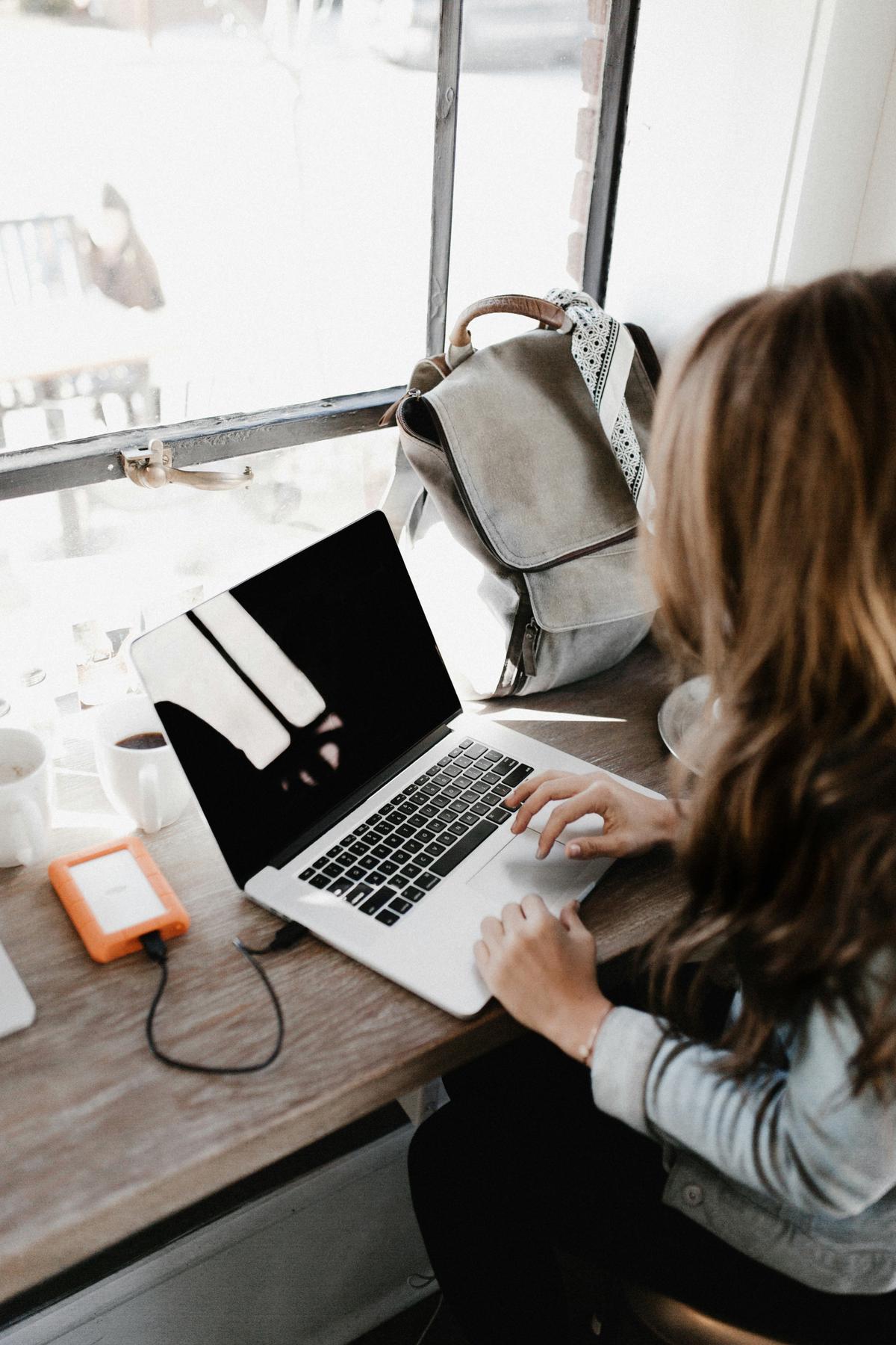 A freelance writer working on a laptop in a coffee shop